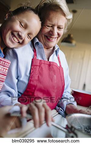 Stock Photography - Grandmother and granddaughter using kitchen sink. Fotosearch