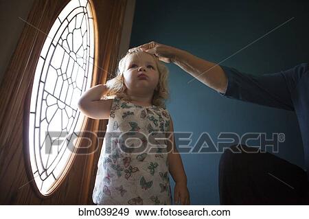 Grandmother patting granddaughter on head near door View Large Photo Image Stock Photo - Grandmother patting granddaughter on head near door. Fotosearch