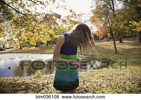 Hair hiding face of woman near duck pond in park View Large Photo Image Stock Photo - Hair hiding face of woman near duck pond in park. Fotosearch