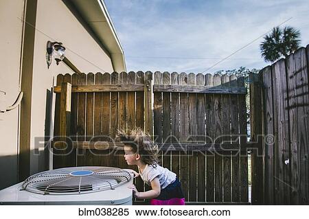 Stock Photography - Hair of mixed race girl blowing from outdoor fan. Fotosearch