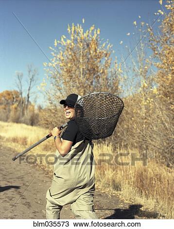 Happy woman carrying fishing net on dirt path View Large Photo Image Stock Image - Happy woman carrying fishing net on dirt path. Fotosearch