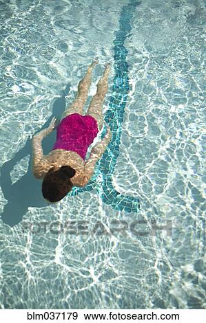 Stock Photo - High angle view of Caucasian woman swimming in pool. Fotosearch