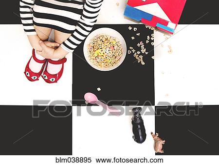 High angle view of girl spilling cereal on floor View Large Photo Image Stock Photography - High angle view of girl spilling cereal on floor. Fotosearch