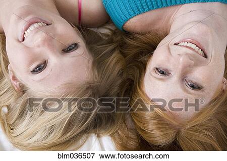 Stock Photo - High angle view of smiling Caucasian sisters. Fotosearch