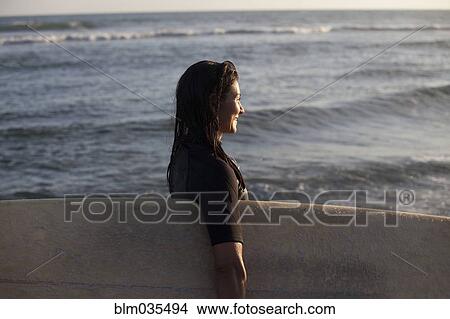 Hispanic surfer carrying surfboard in ocean View Large Photo Image Picture - Hispanic surfer carrying surfboard in ocean. Fotosearch