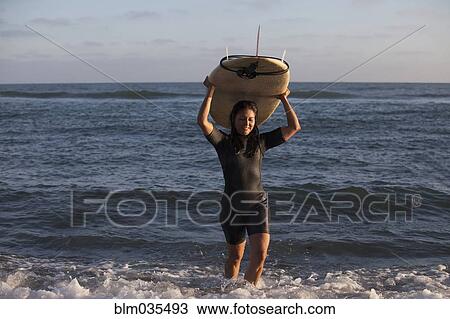 Hispanic surfer carrying surfboard in ocean View Large Photo Image Stock Image - Hispanic surfer carrying surfboard in ocean. Fotosearch