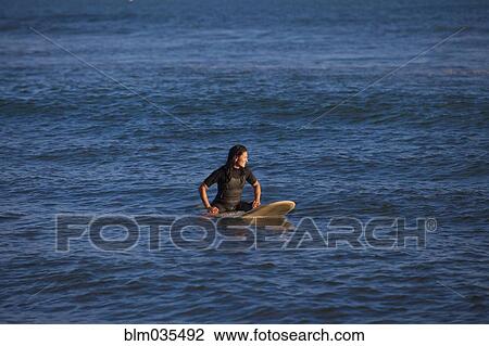 Hispanic surfer floating on surfboard in ocean View Large Photo Image Stock Image - Hispanic surfer floating on surfboard in ocean. Fotosearch