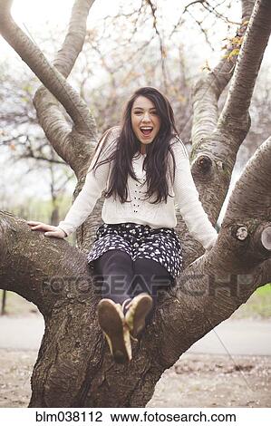 Hispanic woman sitting in tree View Large Photo Image Stock Image - Hispanic woman sitting in tree. Fotosearch