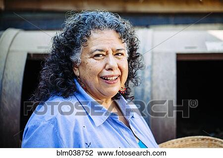 Stock Image - Hispanic woman smiling outdoors. Fotosearch