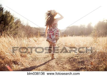 Hispanic woman walking on dirt path in field View Large Photo Image Stock Photograph - Hispanic woman walking on dirt path in field. Fotosearch