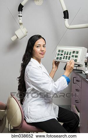 Indian dentist examining x-rays in office View Large Photo Image Stock Image - Indian dentist examining x-rays in office. Fotosearch