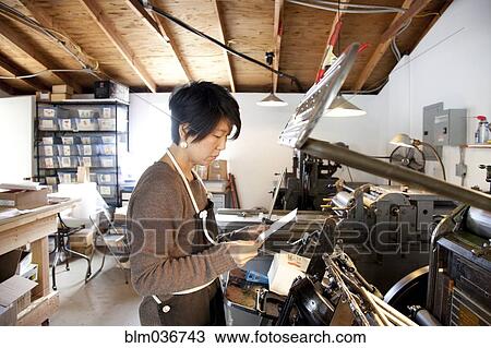 Stock Image - Japanese entrepreneur working in print shop. Fotosearch