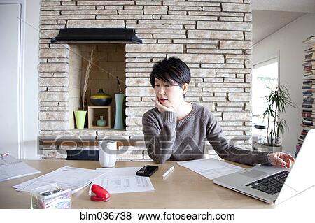 Japanese woman paying bills on laptop View Large Photo Image Stock Photo - Japanese woman paying bills on laptop. Fotosearch