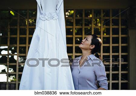 Stock Photograph - Korean bride admiring wedding dress. Fotosearch