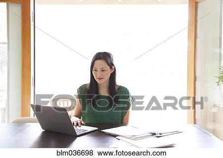 Korean woman paying bills on laptop View Large Photo Image Stock Photo - Korean woman paying bills on laptop. Fotosearch
