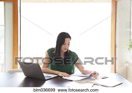 Korean woman paying bills on laptop View Large Photo Image Stock Photo - Korean woman paying bills on laptop. Fotosearch