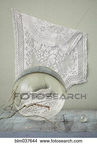 Picture - Lace hanging over crystal balls and branches on table. Fotosearch