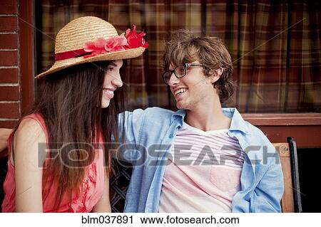 Stock Image - Laughing couple sitting on bench. Fotosearch