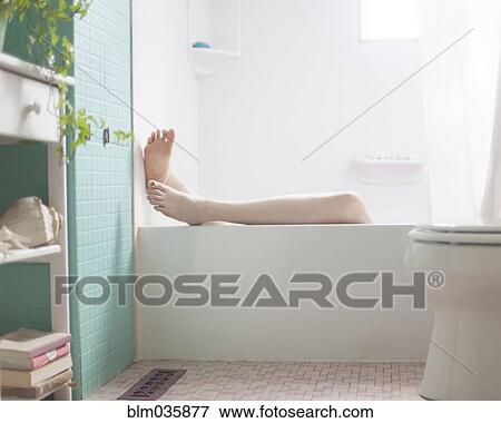 Stock Photo - Legs of Caucasian woman relaxing in bath. Fotosearch