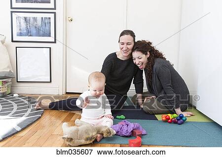 Lesbian couple playing with baby daughter on floor View Large Photo Image Stock Photo - Lesbian couple playing with baby daughter on floor. Fotosearch