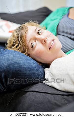 Lesbian couple relaxing on sofa in living room View Large Photo Image Stock Image - Lesbian couple relaxing on sofa in living room. Fotosearch