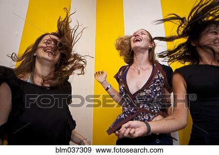 Low angle view of smiling women dancing View Large Photo Image Stock Photo - Low angle view of smiling women dancing. Fotosearch