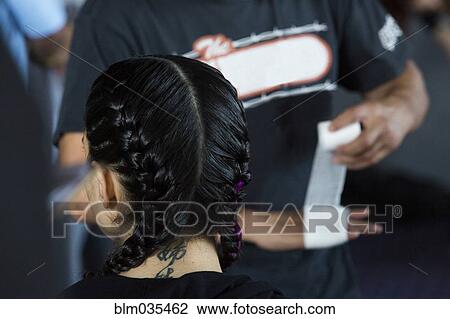 Stock Image - Man wrapping hand near Caucasian girl wearing braids. Fotosearch