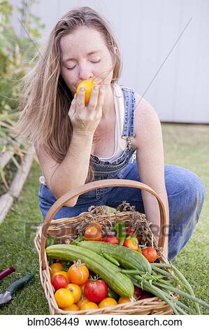 Mixed race farmer smelling vegetables in garden View Large Photo Image Stock Photo - Mixed race farmer smelling vegetables in garden. Fotosearch
