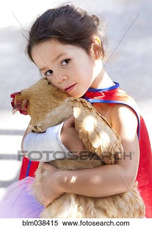 Stock Photography - Mixed race girl hugging chicken. Fotosearch