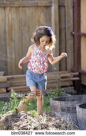 Stock Photo - Mixed race girl playing in backyard. Fotosearch