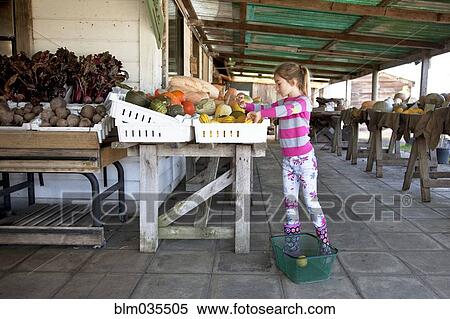 Stock Photography - Mixed race girl shopping in farmers market. Fotosearch