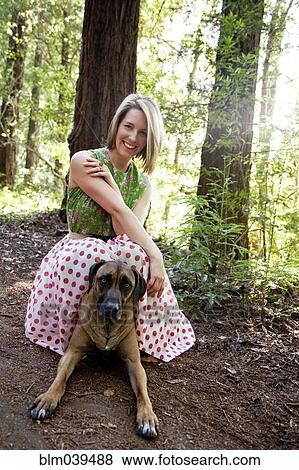 Mixed race woman and dog in forest View Large Photo Image Stock Photo - Mixed race woman and dog in forest. Fotosearch