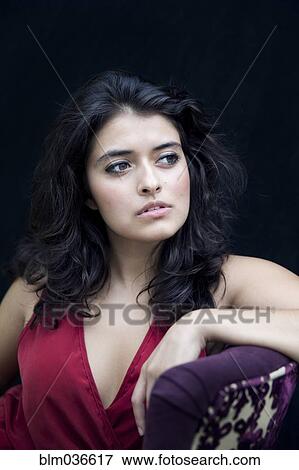 Stock Photo - Mixed race woman leaning on armchair. Fotosearch