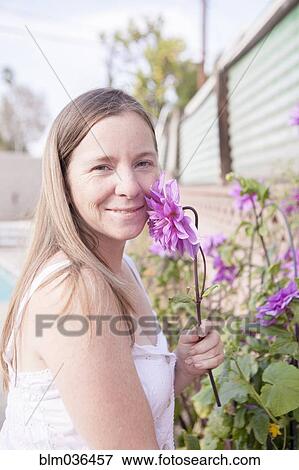 Mixed race woman smelling flowers in garden View Large Photo Image Stock Photo - Mixed race woman smelling flowers in garden. Fotosearch