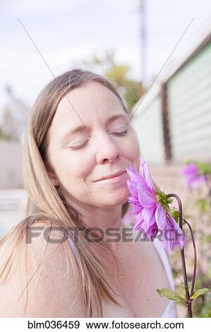 Mixed race woman smelling flowers in garden View Large Photo Image Stock Photo - Mixed race woman smelling flowers in garden. Fotosearch