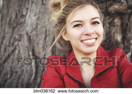 Mixed race woman smiling near tree View Large Photo Image Stock Image - Mixed race woman smiling near tree. Fotosearch