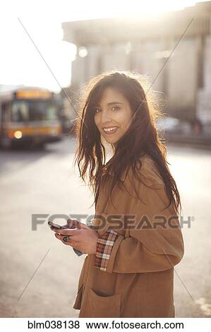 Stock Photo - Mixed race woman using cell phone. Fotosearch