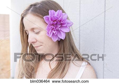 Picture - Mixed race woman wearing flower in her hair. Fotosearch