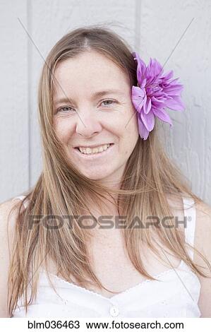 Stock Image - Mixed race woman wearing flower in her hair. Fotosearch