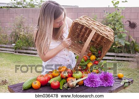 Mixed race woman with basket of vegetables and flowers View Large Photo Image Stock Photo - Mixed race woman with basket of vegetables and flowers. Fotosearch
