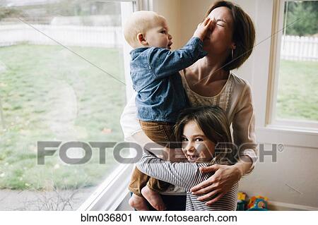Mother and children playing at window View Large Photo Image Stock Image - Mother and children playing at window. Fotosearch