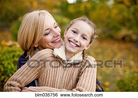 Mother and daughter hugging outdoors View Large Photo Image Stock Photograph - Mother and daughter hugging outdoors. Fotosearch