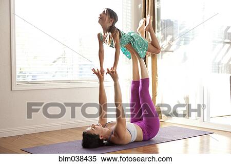 Stock Photography - Mother and daughter practicing yoga in studio. Fotosearch
