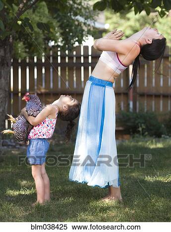 Mother and daughter practicing yoga with chicken in backyard View Large Photo Image Stock Photography - Mother and daughter practicing yoga with chicken in backyard. Fotosearch