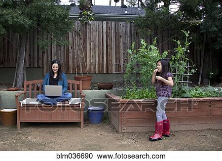 Mother and daughter relaxing in backyard View Large Photo Image Stock Image - Mother and daughter relaxing in backyard. Fotosearch