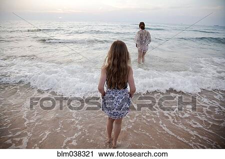 Mother and daughter walking in waves on beach View Large Photo Image Stock Image - Mother and daughter walking in waves on beach. Fotosearch