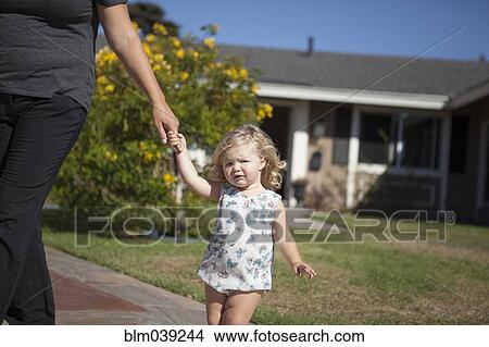 Picture - Mother and daughter walking on sidewalk. Fotosearch