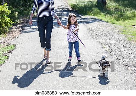 Mother and daughter walking puppy on path View Large Photo Image Stock Image - Mother and daughter walking puppy on path. Fotosearch