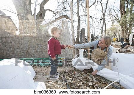 Stock Photo - Mother and son working in autumn garden. Fotosearch