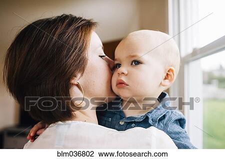 Mother kissing son at window View Large Photo Image Stock Image - Mother kissing son at window. Fotosearch